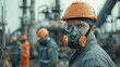 Workers at a chemical industry wear gray uniforms, goggles and orange hard hats.