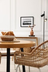 Aufkleber - Tasty croissants on table and wicker chairs in dining room. Interior design