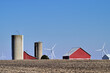 Barns, silos and wind  turbines make up an array of structures that rise above the earth in this section of rural,agricultural Illinois. 