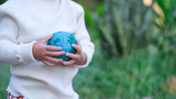 Fototapeta  - Adult person holding world globe, a healthy ecology to a new generation. Healthy ecology of the planet Earth. A healthy future for our generation. green glass background. Save the world.
