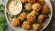 A plate of crispy chickpea and herb falafel with tahini sauce