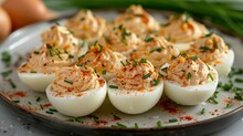 A Plate Of Deviled Eggs With Paprika And Chives