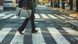 A stylish man confidently crosses the street, gracefully holding a sleek briefcase in one hand, businessman