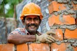 Smiling construction worker building wall with bricks and cement