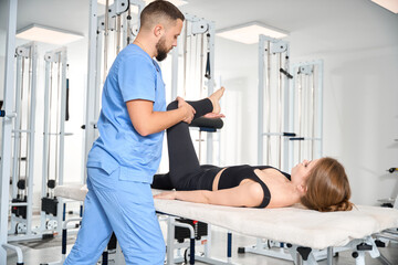 Wall Mural - Physiotherapist working with female patient in rehabilitation center