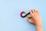 Fototapeta Tulipany - Autistic boy hands and rainbow eight infinity symbol. Autism awareness day symbol.