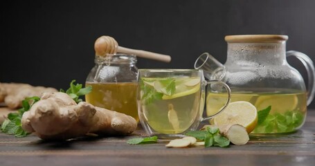 Wall Mural - lemon and ginger hot steaming organic herbal tea in glass mug