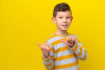 Wall Mural - Little caucasian boy isolated on yellow background pointing to the side to present a product