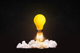 Fototapeta Panele - Creative light bulb rocket with blast and smoke takes off on a black background, concept. Successful launch, creative idea. Think differently. Creative generator. Smart and thinking
