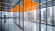 Beautiful blurred background of a modern office interior in gray tones with panoramic windows, glass partitions and orange color accents.