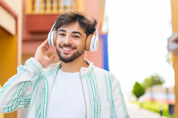 Wall Mural - Handsome Arab man at outdoors listening music