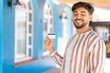 © luismolinero - Handsome Arab man holding a credit card at outdoors smiling a lot