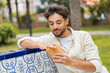 © luismolinero - Young Arabian handsome man holding fried chips at outdoors