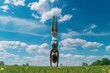 Woman doing a handstand on a grassy field