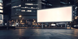 Fototapeta  - A large blank billboard in the center of an empty city square at night, illuminated by soft white light. Minimalist and modern atmosphere blank white advertising billboard mockup. 