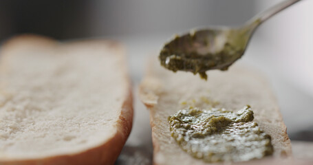 Wall Mural - man spread pesto on baguette halves, making sandwich