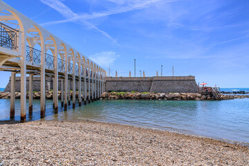 Wall Mural - Cityscape of Civitavecchia in Italy: view of Pirgo beach with its pedestrian bridge.