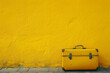 yellow suitcase on a bright yellow wall in the style  a350f4e6-5ef3-40fd-9598-ca8b2a5f05b8 0