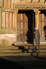 Wall Mural - Ornate Carving and Cast Iron Railing at Stepped Entrance to Victorian Stone Church 