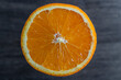 Close up of sliced ripe orange, macro. Yellow fresh orange surface on wooden background