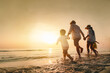 © Garun Studios - sea, beach, brother, childhood, sunset, summer, children, together, parent, happiness. A family is running on the beach, enjoying the sunset. as the family is spending quality time together.