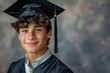 Handsome young graduate with freckles in cap and gown