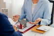 © Witoon - A real estate agent talks with his client regarding a home purchase contract, concept for real estate, moving house or renting property.
