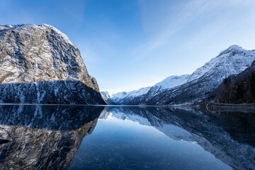 Wall Mural - Stunning winter scene of a beautiful snow-capped mountain reflected in a lake in Olden, Norway