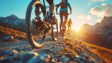 Low Angle View Of Cross Country Bikers Traveling In Mountain Landscape At Sunset
