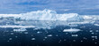 Riesiger Eisberg spiegelt sich im blauen Wasser des Eisfjords bei Ilulissat, Grönland