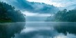 Mountain lake at dawn with mist rising from the water surrounded by lush greenery. Concept Nature Photography, Dawn Landscapes, Serene Outdoors