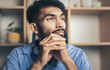 © Pituk - Thoughtful young bearded man sad looking out window while sitting on desk at home office