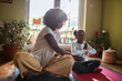 © Marko Geber - Young mother teaching her daughter how to do yoga and meditate at home