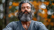 © amixstudio - Portrait of a gray-haired bearded man yogi meditating in the forest