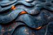 Close-up of a dimpled dark surface with rhythmic wavy patterns highlighted by orange reflections