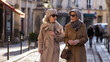 two elderly respectable women are walking along the street of a European city in autumn or spring. stylish luxury grandmothers in beige coats. quiet luxury