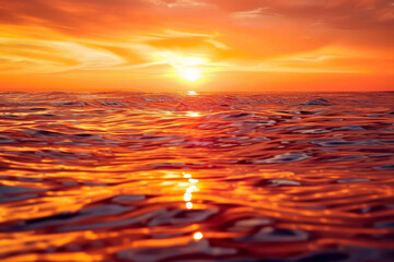 Wall Mural - The sun is setting over the ocean, casting a warm glow on the water