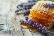Close-up of golden honey in honeycombs with lavender sprigs on rustic wooden table