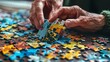 Elderly hands assembling jigsaw puzzle on a table. Cognitive exercises and memory maintenance concept