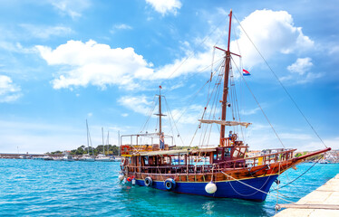 Wall Mural - Pirate ship in the harbour on the island of Krk with crystal-clear turquoise water, Croatia