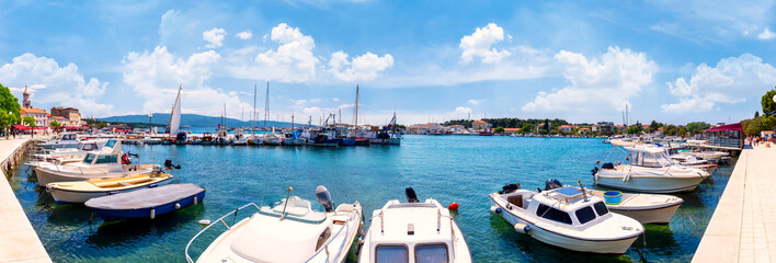 Wall Mural - Boats in the harbour with crystal-clear turquoise water on the island of Krk, Croatia