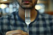 Man Holding Fork at Table