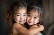 Two Asian twin girls hug, laugh and look at the camera. National Siblings Day. National Gemini Day. Twins Days. Copy space