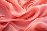 Fototapeta Tęcza - The elegant coral silk material, carefully draped to emphasize the interplay of shadows and light on its graceful folds, is ideal for graphic design backgrounds focusing on fashion and interior decor.