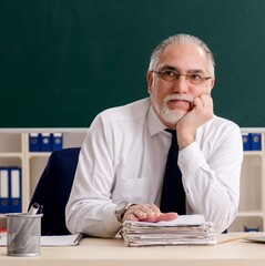 Wall Mural - Aged male teacher in front of chalkboard