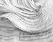 Close up of sheets of paper with music notes in the background.