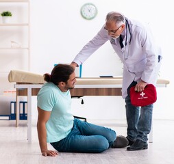 Wall Mural - Experienced doctor and young male patient in first aid concept