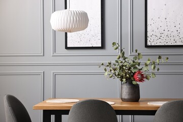 Wall Mural - Soft chairs, table and vase with plants in stylish dining room