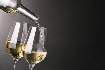 Sticker - Pouring white wine into glass against grey background, closeup. Space for text