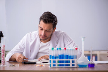 Wall Mural - Young male chemist in front of white board